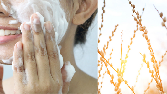 a woman washing her face next to a field of sunlit natural branches