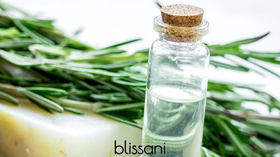 A branch of rosemary with a bottle of rosemary extract