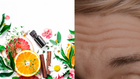 A collection of fresh ingredients including citrus slices, herbs, and flowers arranged around a small essential oil bottle, representing natural skincare options for reducing wrinkles.