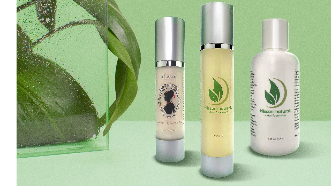 A plant and a sheet of glass with water droplets, a bottle of Gemma Crema Anti-Aging Serum, A bottle of blissani Naturals Clear Face Wash, A bottle of blissani Naturals Clear Face Toner